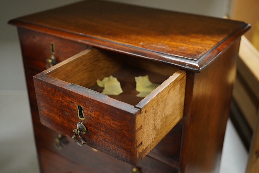 A George III style mahogany miniature chest of five drawers, 30cm high. Condition - fair/good